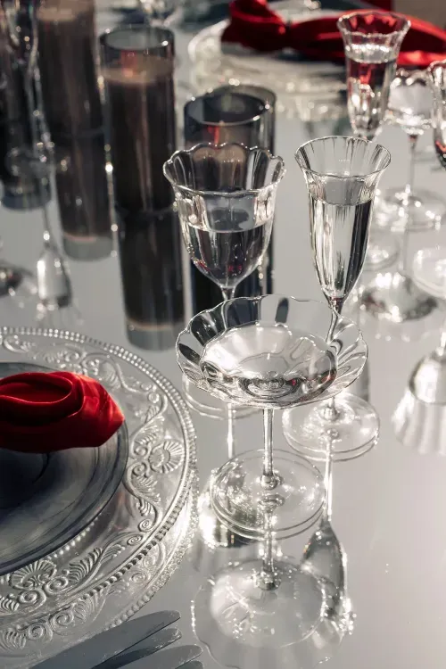 Прозрачно-дымчатый сет с красными акцентами за белым зеркальным прямоугольным столом