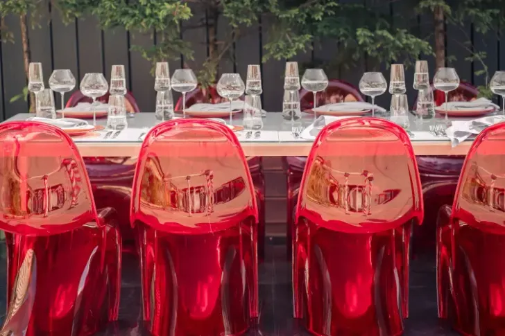 Современная сервировка с красными акцентами за белым прямоугольным столом